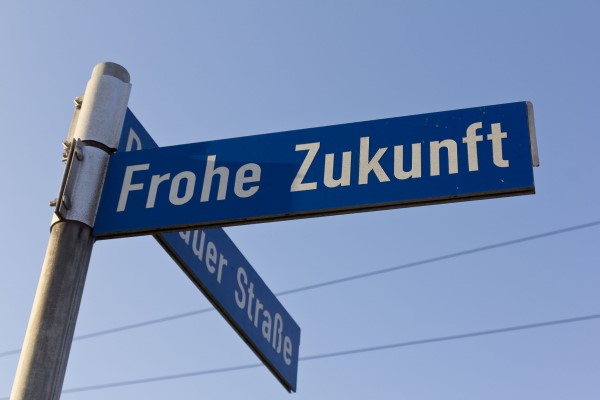 Straßenschild an der Ecke Frohe Zukunft und Dessauer Straße mit blauem Himmel im Hintergrund