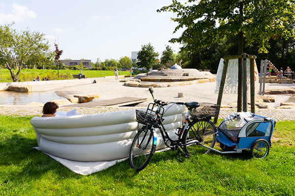 Dörte Jacobi auf dem Sofa des Sofalogs vor dem Wasserspielplatz in Heide-Süd bei sonnigem Spätsommerwetter