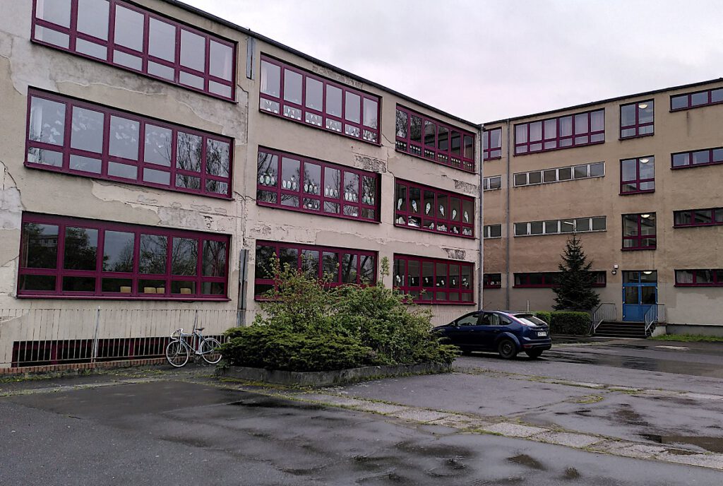 Ansicht der heruntergekommenen Grundschule Südstadt vom Parkplatz aus